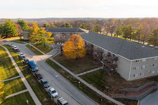 A parking lot with cars and a building in the background at Rosemont Place Apartments, Iowa, 50320