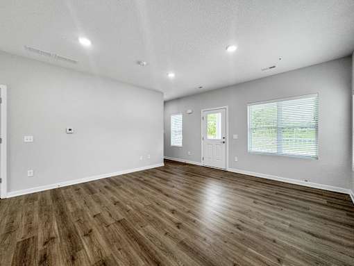 the living room of a new home with white walls and wood floors at Soll, Des Moines, IA 50312  