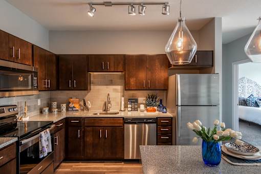 a kitchen with wooden cabinets and stainless steel appliances at Soll, Des Moines  