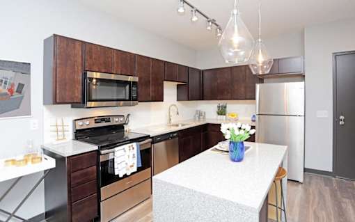 a kitchen with stainless steel appliances and a white counter top at Soll, Des Moines, IA 50312  