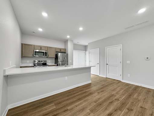 a kitchen and living room with a counter top and a refrigerator at Soll, Des Moines Iowa   