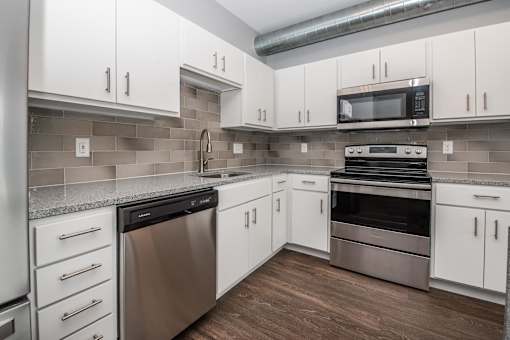 a kitchen with white cabinets and stainless steel appliances at Soll, Des Moines, 50312  
