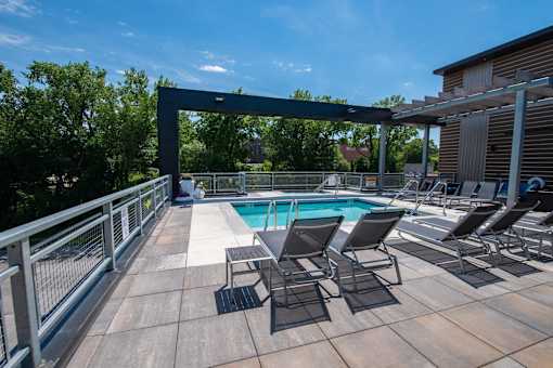 the pool on the rooftop of a building with lounge chairs at Soll, Des Moines, IA 50312  