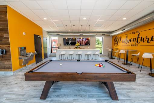 a pool table in a room with a bar and a tv at Soll, Des Moines, 50312  