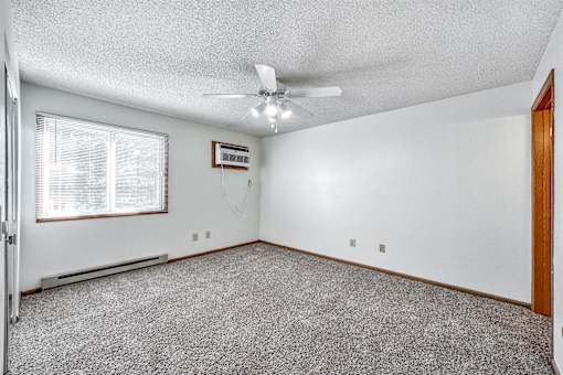 A room with a ceiling fan and a window with blinds at Somerset Apartments, Iowa