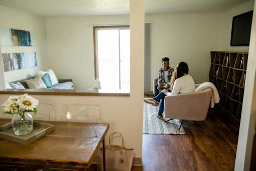 Two people sitting on a couch in a living room at Sutton Hill Apartments, Des Moines, 50320