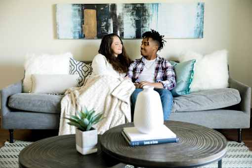 a couple sitting on a couch in a living room at Sutton Hill Apartments, Des Moines