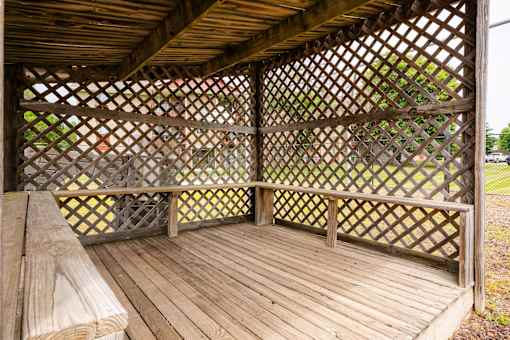a gazebo with a wooden deck and a bench at Sutton Hill Apartments, IOWA, 50320