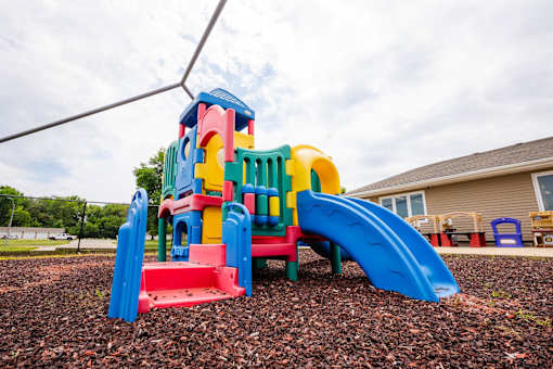 a multicolored play set in a yard at Sutton Hill Apartments, Des Moines, 50320