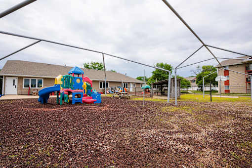 a playground with a play set in front of a building at Sutton Hill Apartments, Des Moines, IOWA