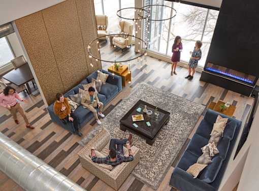people in a living room with couches and a tv at Velocity Apartments, Iowa