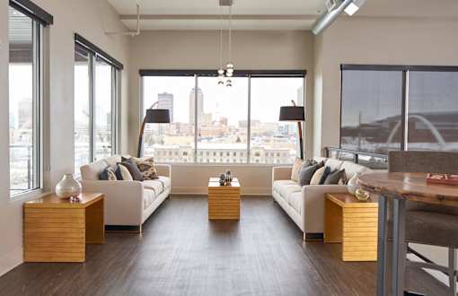 a living room with white couches and a view of the city at Velocity Apartments, Des Moines