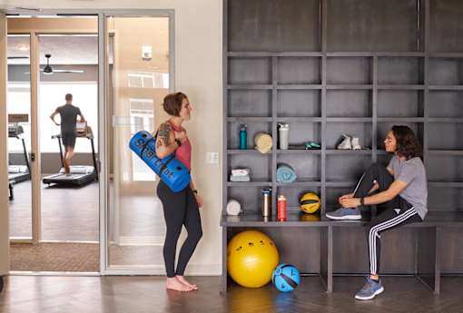 two women working out in a gym with weights and a yoga ball at Velocity Apartments, IA, 50309