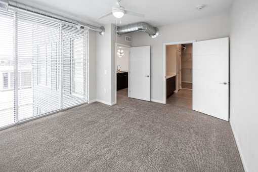 A room with a grey carpet and white walls at Velocity Apartments, Des Moines, IA