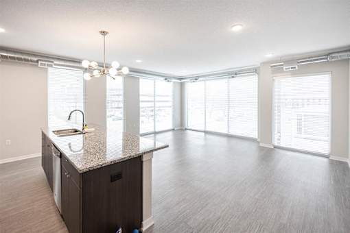 A kitchen with a granite countertop and a sink at Velocity Apartments, IA, 50309