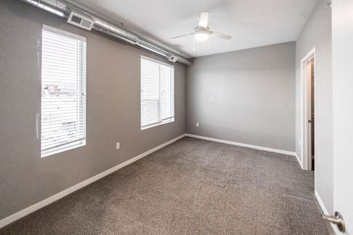A room with a carpeted floor and a ceiling fan at Velocity Apartments, Des Moines, Iowa