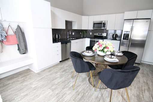 A kitchen with a table and chairs in the middle at Velocity Apartments, Iowa, 50309