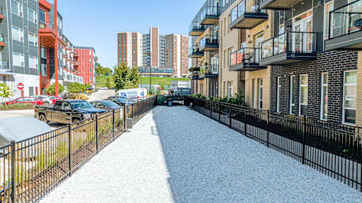A gravel pathway leads through a residential area with apartment buildings on either side at Velocity Apartments, Des Moines, Iowa