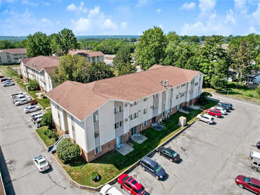 an aerial view of an apartment building with a parking lot at Foxwood Apartments, Indianola Iowa  