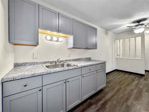 an empty kitchen with white cabinets and a sink at Foxwood Apartments, Indianola, IA  