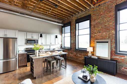 A kitchen with a brick wall and wooden ceiling.at Plant 1 Lofts, Iowa, 50208