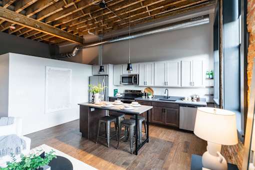 A kitchen with a wooden ceiling and a table with chairs.at Plant 1 Lofts, N. Newton, IA  