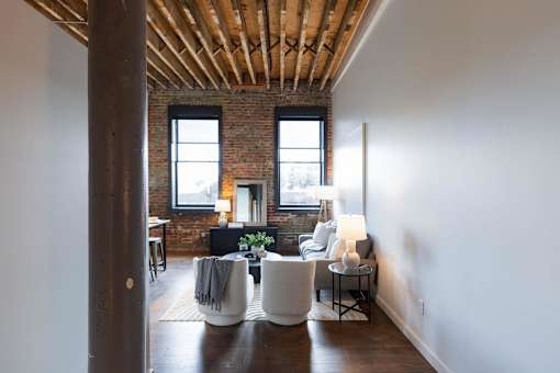 A living room with a white couch and a wooden floor.at Plant 1 Lofts, N. Newton, 50208  