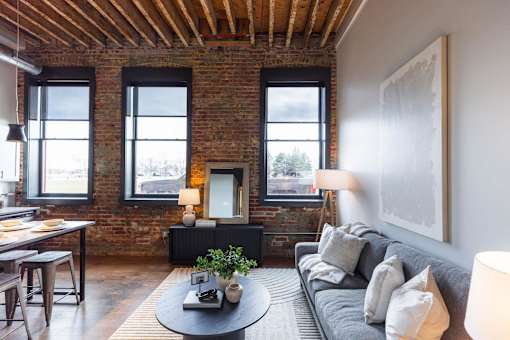 A living room with a grey couch and a round coffee table.at Plant 1 Lofts, N. Newton, IA 50208  