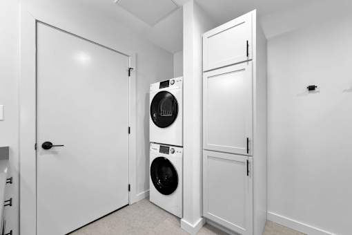 A laundry room with a washer and dryer stacked on top of each other.at Plant 1 Lofts, N. Newton  