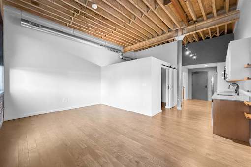 A room with wooden floors and a white wall.at Plant 1 Lofts, N. Newton, IA 50208  