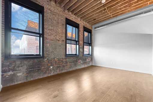 A room with a brick wall and wooden ceiling.at Plant 1 Lofts, N. Newton Iowa   