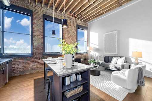 A kitchen with a table and chairs in front of a window.at Plant 1 Lofts, N. Newton, IA 50208  