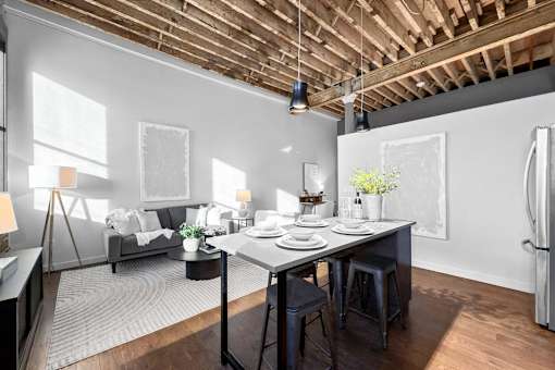 A modern kitchen with a dining table set for two.at Plant 1 Lofts, N. Newton, IA  