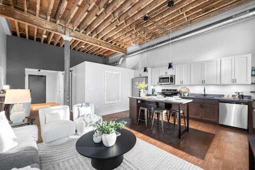 A modern kitchen with a wooden ceiling and a dining table with chairs.at Plant 1 Lofts, Iowa   