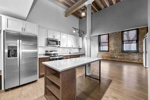 A kitchen with a refrigerator, microwave, and oven.at Plant 1 Lofts, Iowa, 50208