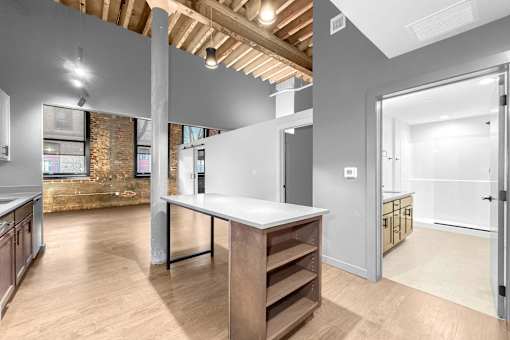 A kitchen with a large island in the middle of the room.at Plant 1 Lofts, N. Newton, IA  