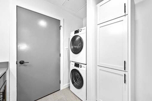 A white laundry room with a washer and dryer.at Plant 1 Lofts, Iowa, 50208
