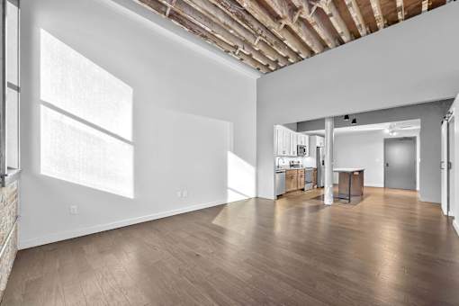 A large empty room with wooden floors and white walls.at Plant 1 Lofts, N. Newton, 50208  