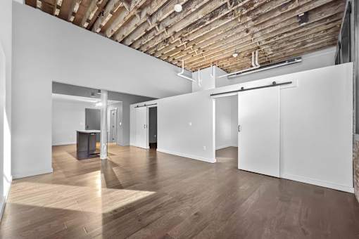 A room with wooden floors and ceiling with white walls and doors.at Plant 1 Lofts, Iowa   