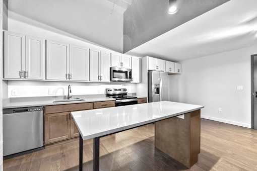 A modern kitchen with a large island in the center.at Plant 1 Lofts, N. Newton Iowa   