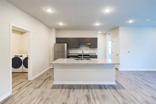 a kitchen with a island and a stainless steel refrigerator at Forge65, Pleasant Hill, IA, 50327