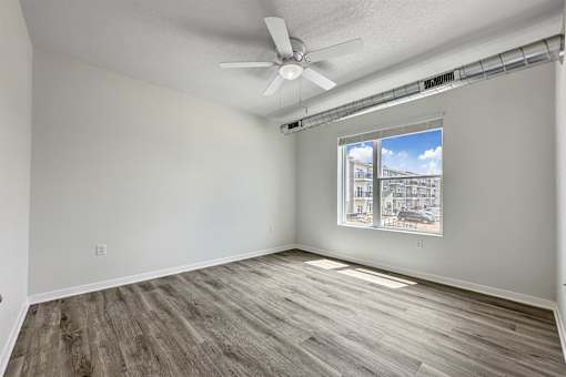 an empty living room with a ceiling fan and a window at Forge65, Iowa, 50327
