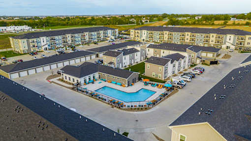 an aerial view of an apartment complex with a swimming pool at Forge65, Pleasant Hill, 50327