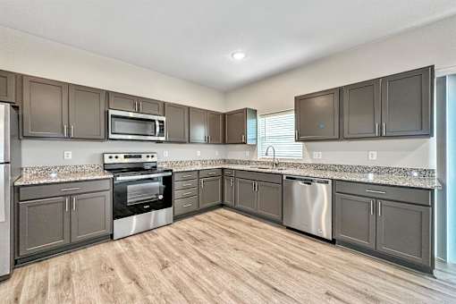 a kitchen with stainless steel appliances and granite counter tops at Forge65, Pleasant Hill, Iowa