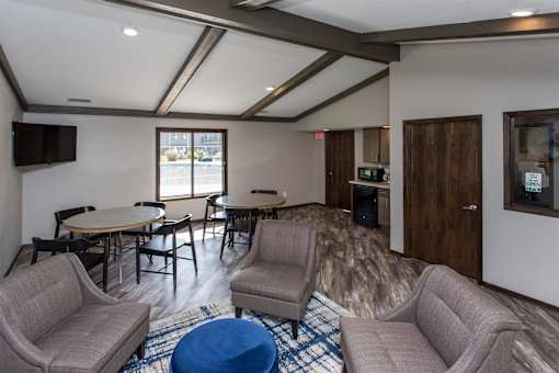 a living room with couches chairs and tables and a tv  at Bristol Ridge, Urbandale, IA
