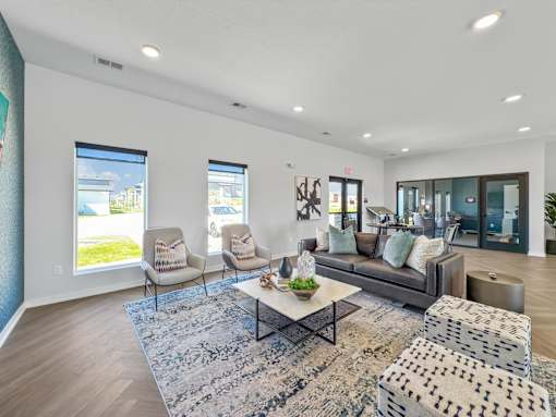 a living room with couches and chairs and a rug at Rialto Townhomes Apartments, Iowa, 50263