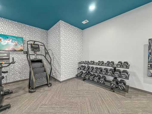 a gym with weights and a treadmill in the corner of a room at Rialto Townhomes Apartments, Waukee