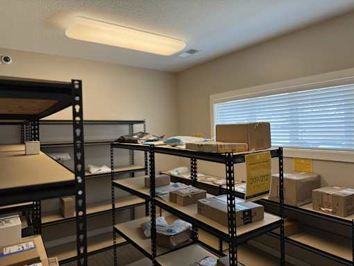 A storage room with shelves filled with boxes and a sign that reads "20-212".