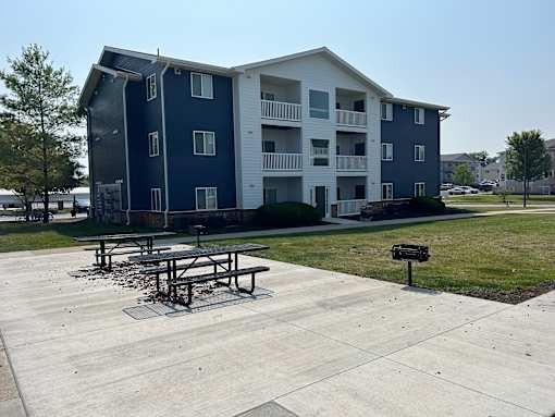A large apartment complex with a picnic table in front.