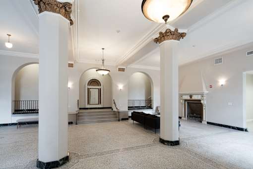 A large, empty room with white walls and a fireplace.
